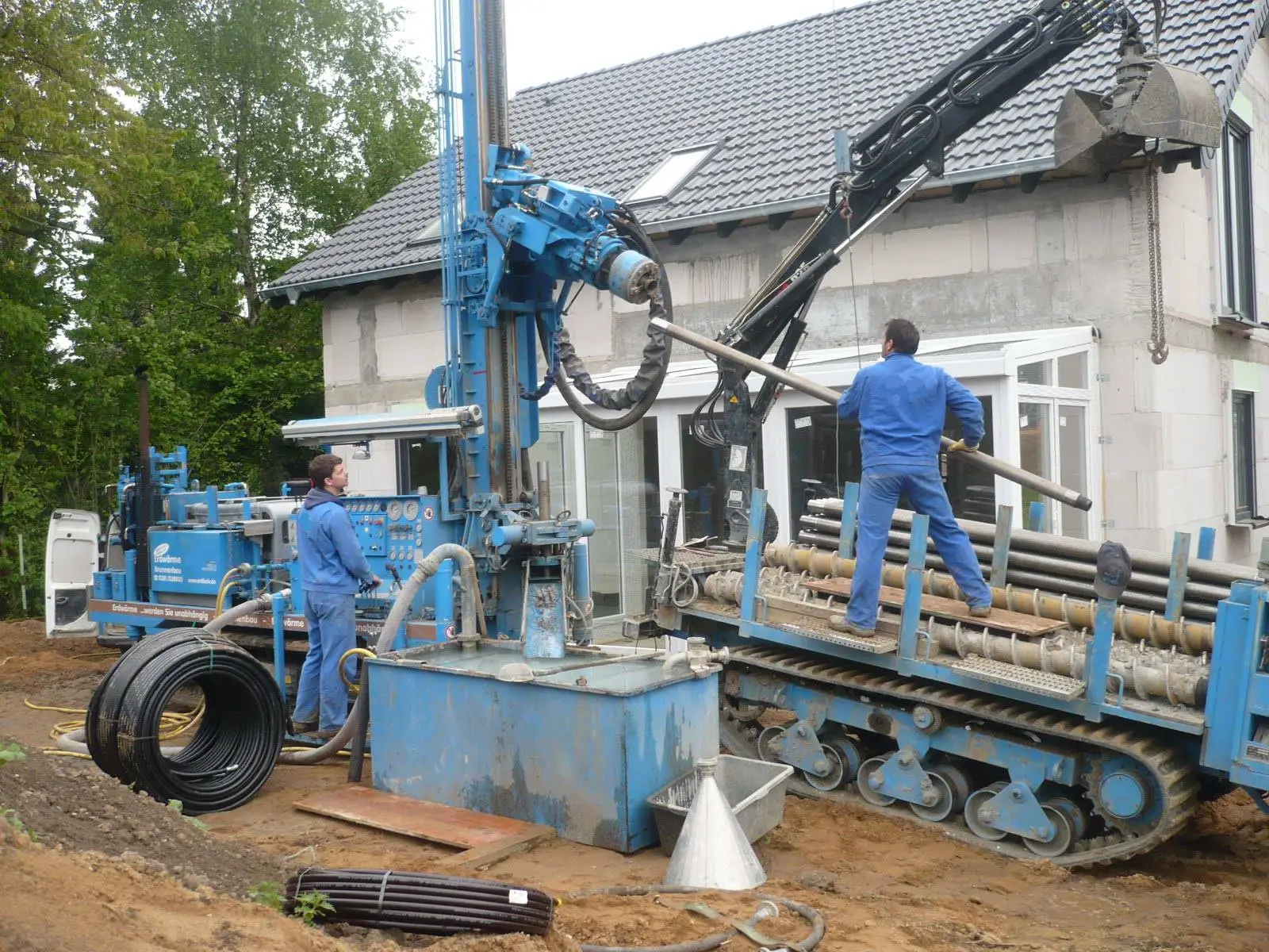 Foreuse sur chenilles devant une maison : forage d’une sonde géothermique verticale